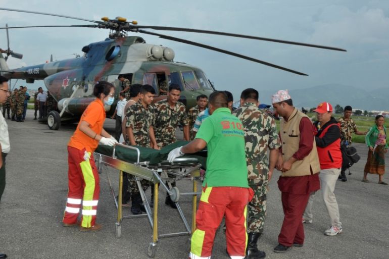Nepalese army personnel assist a victim of a bus accident after being airlifted from Birtadeurali in Kavre to Kathmandu