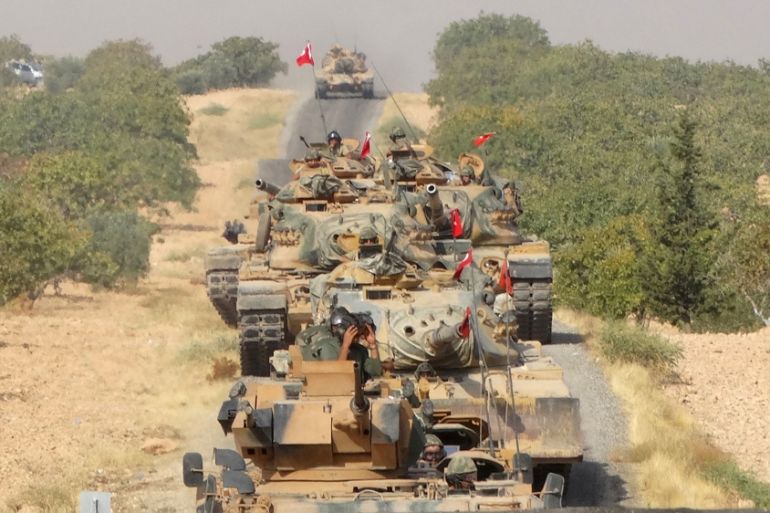 Turkish army tanks make their way towards the Syrian border town of Jarablus