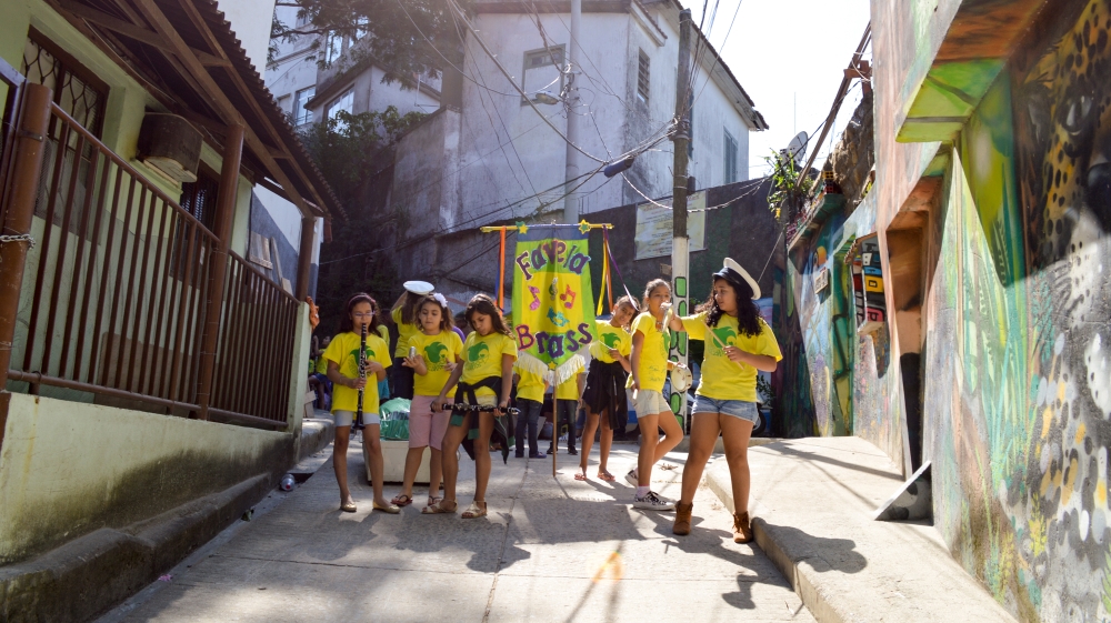 Children from the Favela Brass music school parade through the favela on Friday [Matt Taylor/Al Jazeera]