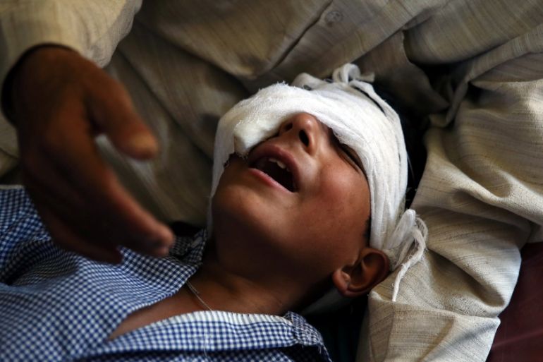 A father comforts his son whom he said was injured by pellets shot by security forces in Srinagar following weeks of violence in Kashmir