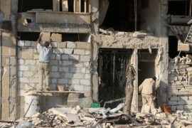 A man rebuilds a wall of a damaged building in the rebel held al-Katerji district in Aleppo