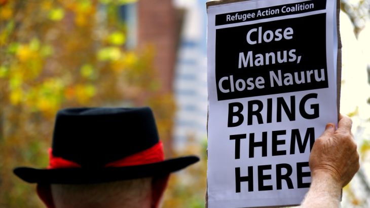 A protester from Refugee Action Coalition holds placard during demonstration outside offices of the Australian Government Department of Immigration and Border Protection in Sydney, Australia