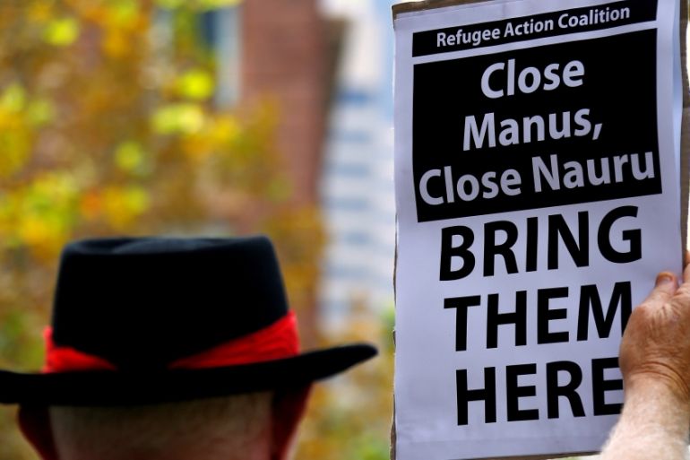 A protester from Refugee Action Coalition holds placard during demonstration outside offices of the Australian Government Department of Immigration and Border Protection in Sydney, Australia