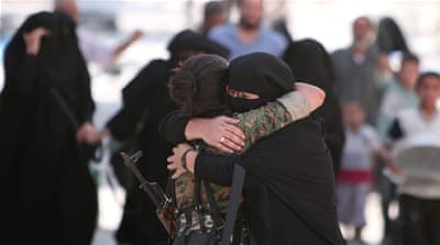 A woman embraces an SDF fighter after she was evacuated with others by the SDF from ISIL-controlled Manbij [Reuters]