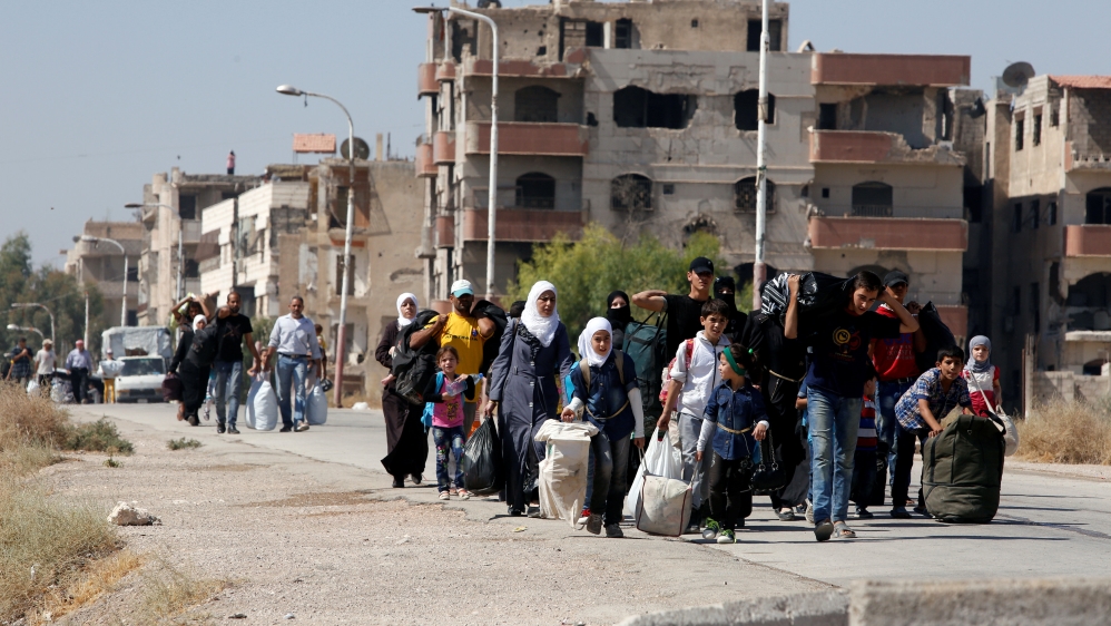 Civilians carry their belongings after reports of an agreement between rebels and Syria's army to evacuate civilians and rebel fighters from Mouadamiyah, in Damascus [Reuters]