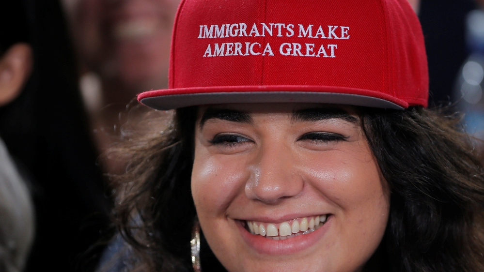 A Clinton supporter wears a cap mocking the style of hats worn by Trump [Brian Snyder/Reuters]