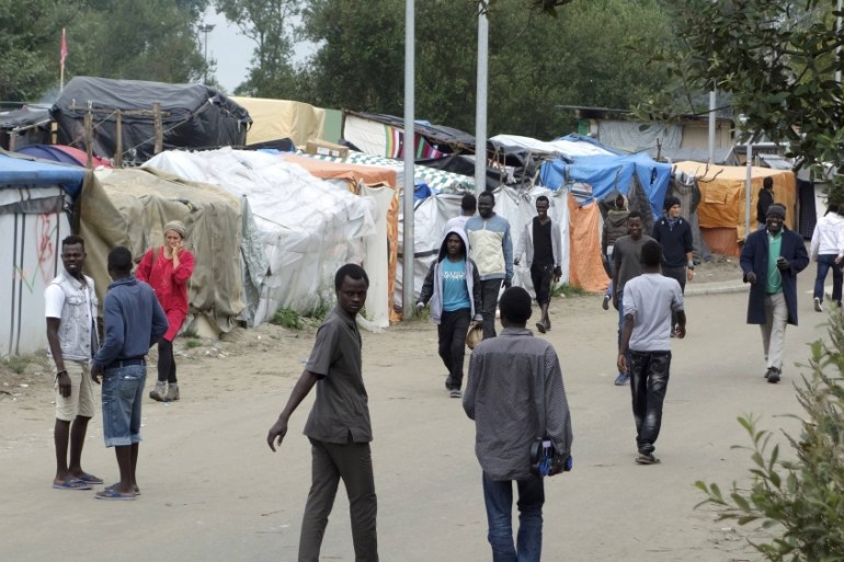 Migrants walk in the northern area of the camp called the "Jungle" in Calais, France