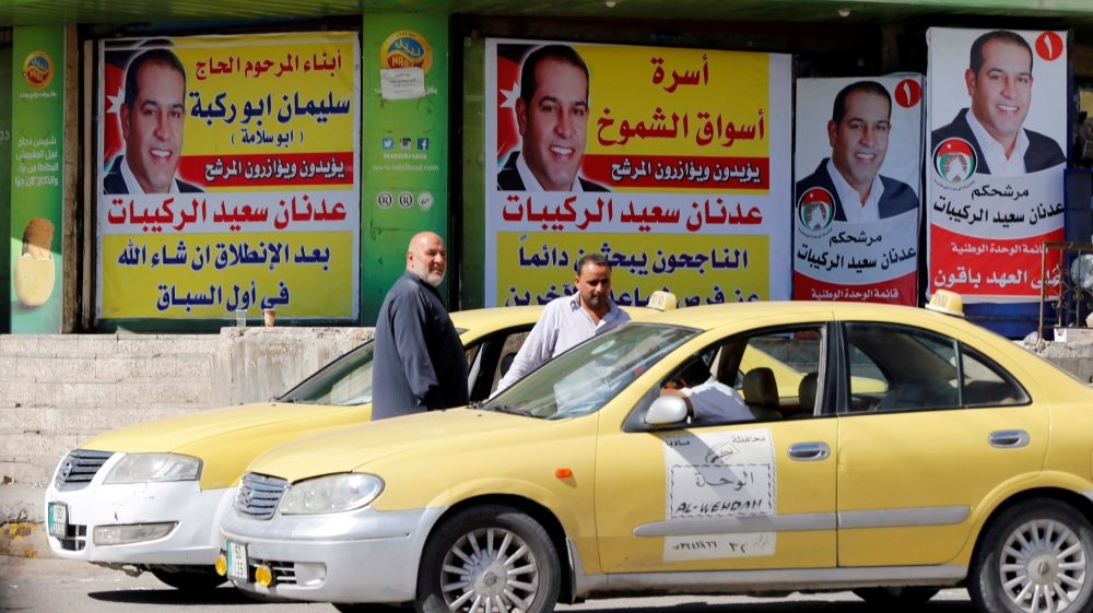 Posters for parliamentary candidates hang in Madaba, near Amman, before the general elections on Tuesday [Muhammad Hamed/Reuters]