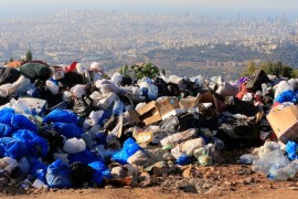 Piled garbage bags are seen in Ain Anoub village overlooking the city of Beirut