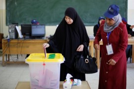 A woman casts her ballot at a polling station for parliamentary elections in Amman