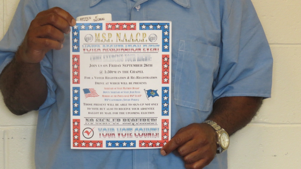 Foster Bates displays the poster he has made encouraging fellow inmates to register to vote [Jessica Sarhan/Al Jazeera]