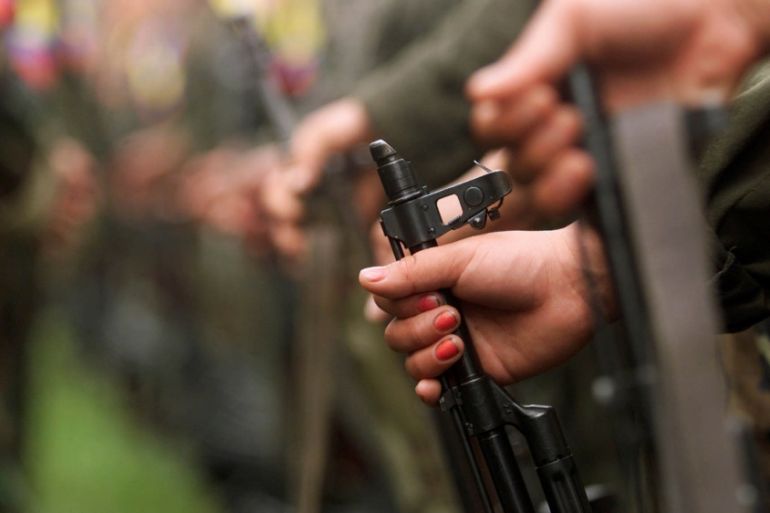 A Colombian guerilla woman holds her gun as she takes part in a line of rebels during an army parade of fighters of the FARC in Villa Colombia camp near San Vicente del Caguan