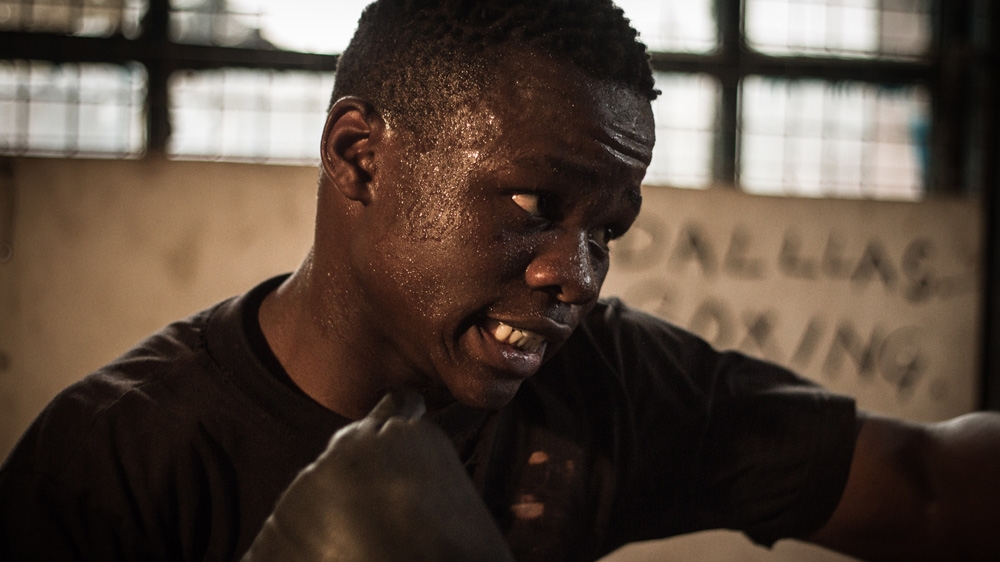 Robinson Ngira works out on the Dallas Boys boxing club's only punching bag [Humphrey Odero/Al Jazeera] 