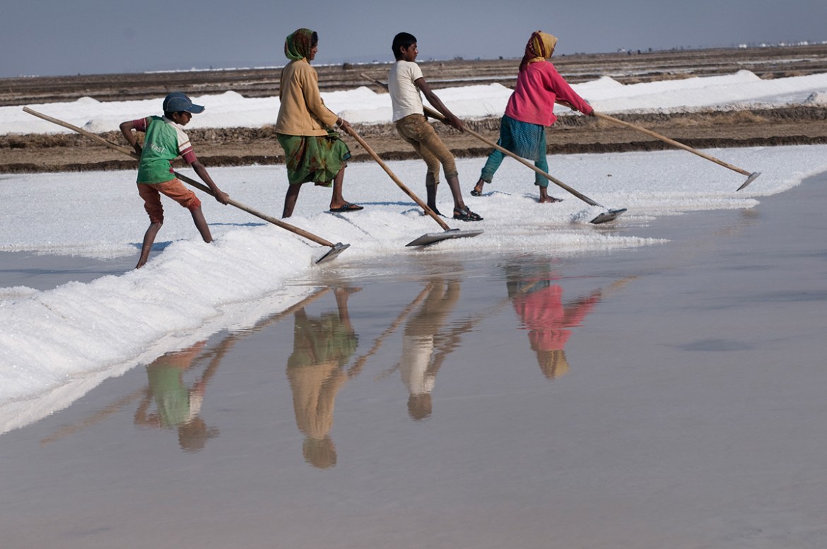 An Agariya family working in their salt pan in Surajbari creek in Rann of Kutch. Agariya children start working in the salt fields from the age of 10 and do not attend school as a result. [Sugato Mukh