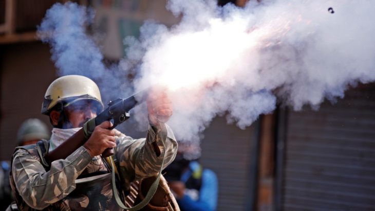 An Indian policeman fires a teargas shell towards demonstrators during a protest against the recent killings in Kashmir, in Srinagar