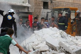 Civil defence members and civilians search for survivors under the rubble of a damaged site hit by airstrikes in Idlib