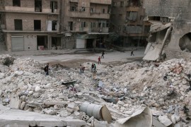 People walk on the rubble of damaged buildings in the rebel held area of al-Kalaseh neighbourhood of Aleppo