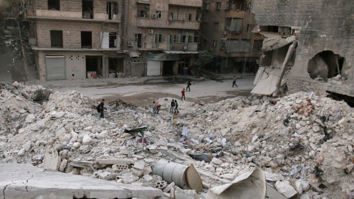 People walk on the rubble of damaged buildings in the rebel held area of al-Kalaseh neighbourhood of Aleppo