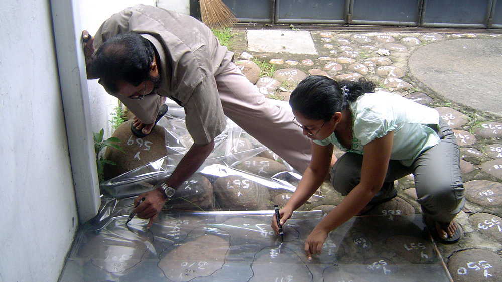 Working with a team member, Nilan Cooray, left, laboriously traces the placement of each boulder in the front courtyard   [Courtesy of Bawa Trust] 