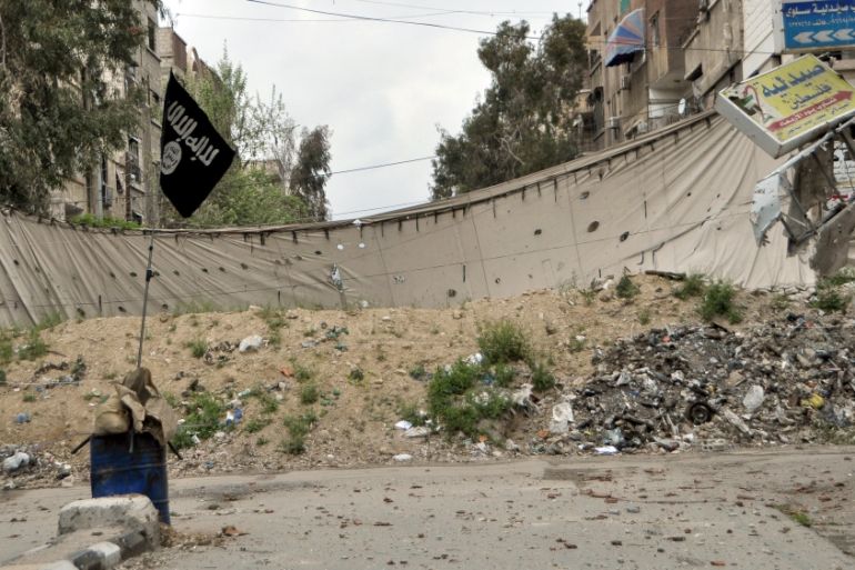 An Islamic State flag is seen near a barricade, which serves as protection from snipers of forces loyal to Syria''s President Bashar al-Assad, in Yarmouk Street, the main street of Yarmouk camp