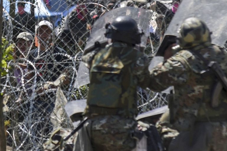 Macedonian police officers try to protect border fence attacked by the refugees and migrants from the Greek side of the border