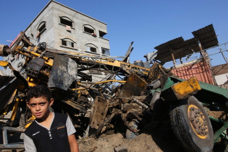 A Palestinian boy looks at the damage following an airstrike by the Isreali army on a workshop in Gaza City [EPA]