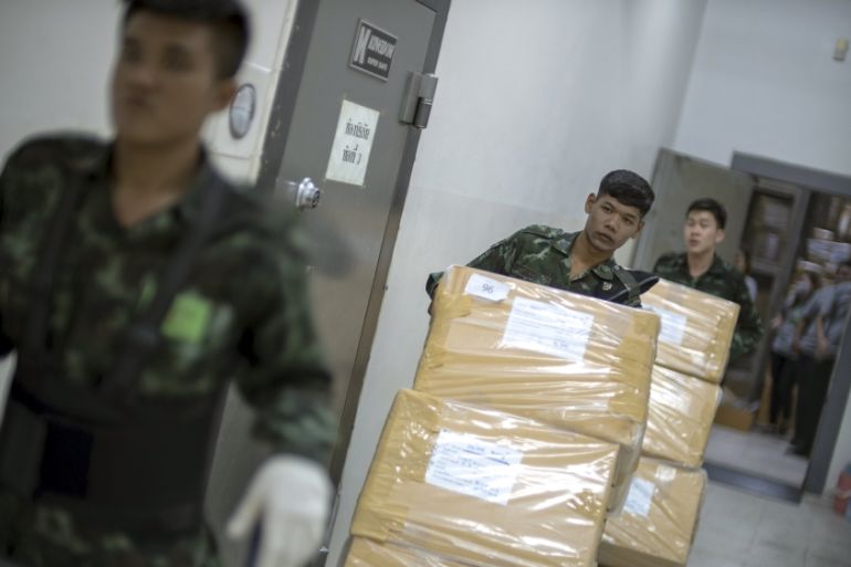 Thai military personnel carry boxes of confiscated drugs, which will be destroyed on Friday, at the Food and Drug Administration in Bangkok