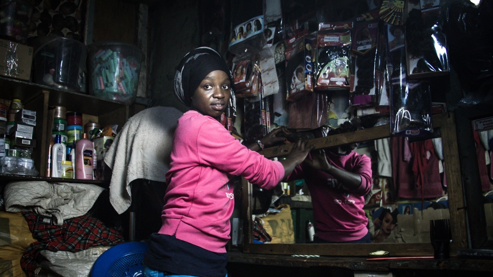 Veronica Mbithe works in her mother's salon before training [Humphrey Odero/Al Jazeera] 