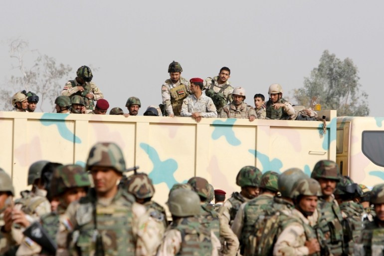 Iraqi security forces ride in trucks travelling to Mosul to fight against militants of Islamic State at an Iraqi army base in Camp Taji in Baghdad