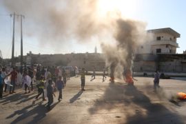 People gather near burning tyres during a demonstration against forces loyal to Assad and calling for aid to reach Aleppo near Castello road in Aleppo, Syria [REUTERS]