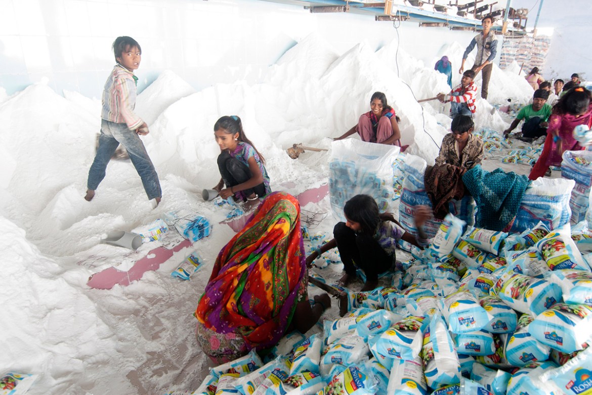 Agariya women and children work in local salt factories. The pay for packing 1,000 packets of salt is as low as 80 Indian rupees ($1.30). [Sugato Mukherjee/Al Jazeera]