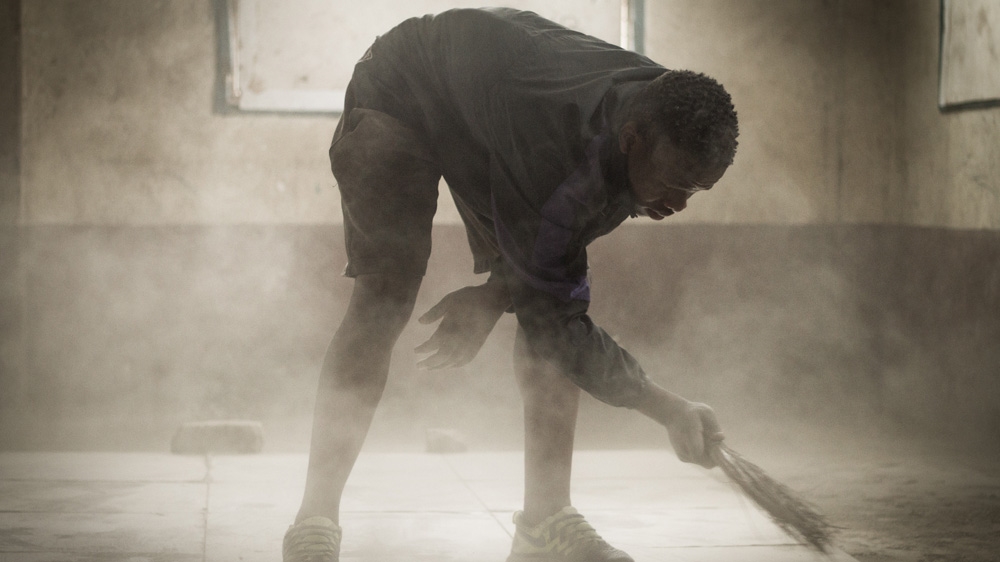 Robinson Ngira, 17, cleans up inside the Muthurwa gym before training [Humphrey Odero/Al Jazeera] 