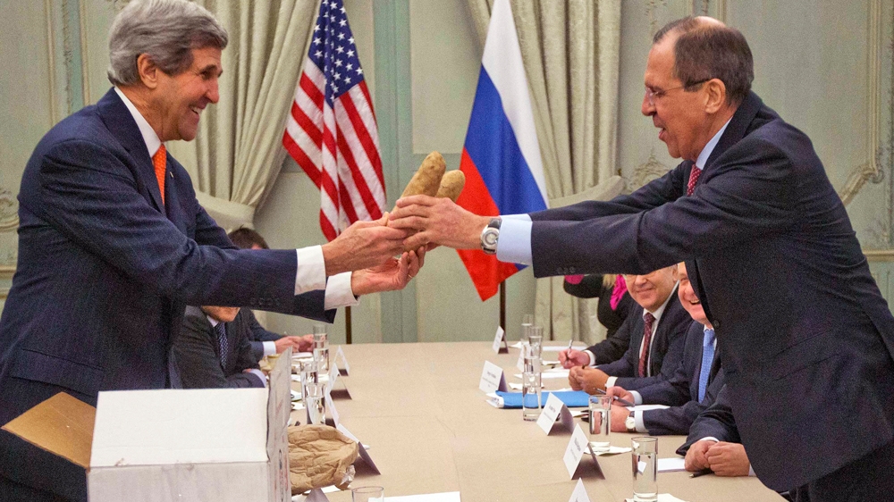 Kerry, left, gives a pair of Idaho potatoes as a gift for Lavrov at the start of their meeting at the US ambassador's residence in Paris, France, January 2014 [AP]