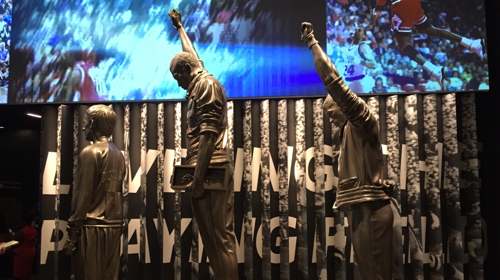 
A sculpture of athletes John Carlos and Tommie Smith raising a black power fist at the 1968 Mexico City Olympics. Peter Norman, an Australian sprinter, who wore a small badge to support them, is also included [Dalia Hatuqa/Al Jazeera]

