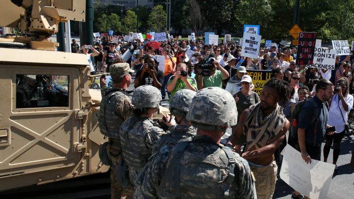 A protester greets national guard soldiers during a march through the streets to protest the police shooting of Keith Scott in Charlotte, North Carolina