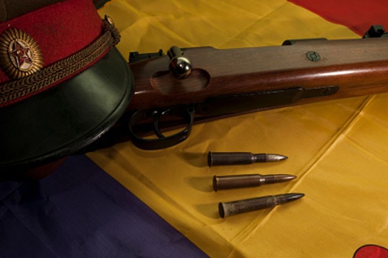 A Soviet cap, a rifle and a few bullets on a flag of the Spanish Republic [Getty]