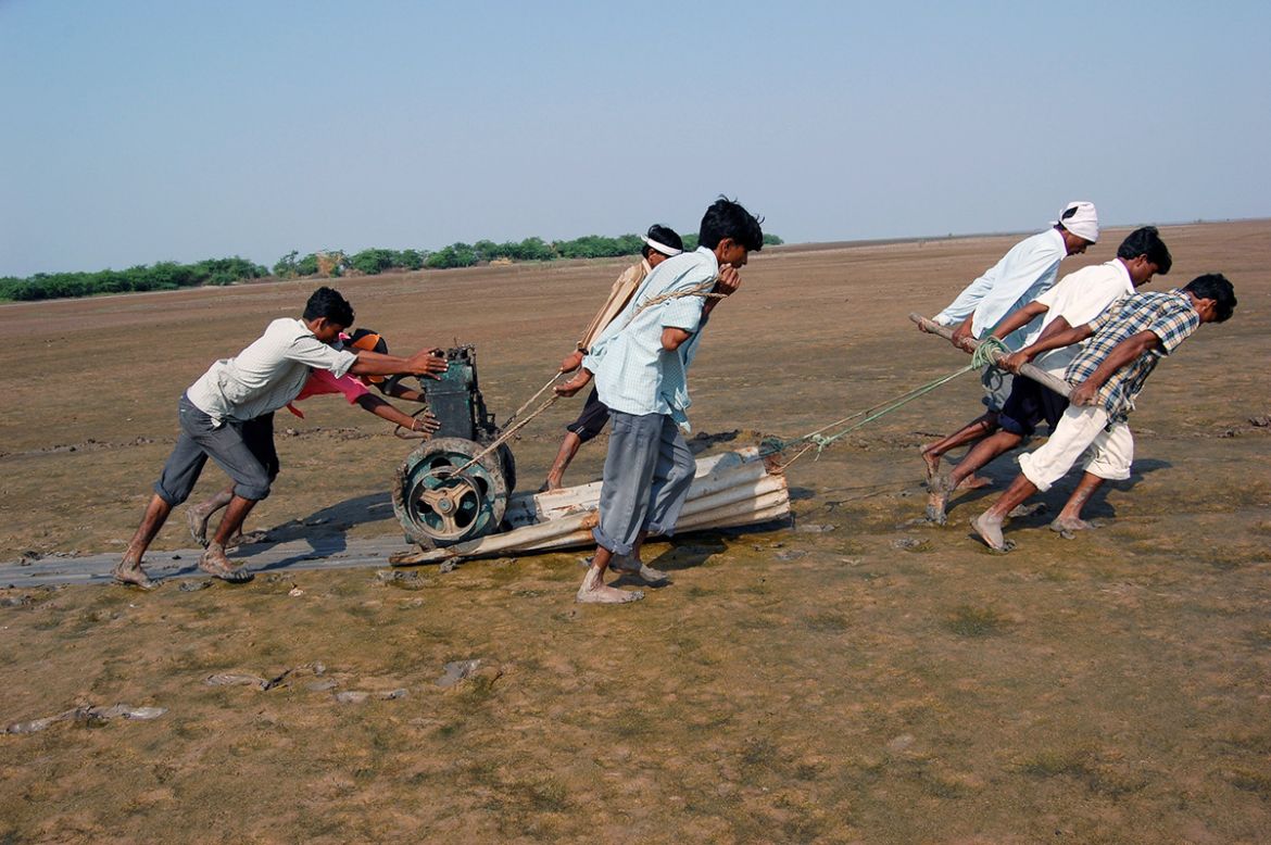 It is a herculean task to carry the equipment over the marshy tract as no vehicle can negotiate the road in the post-monsoon season. Workers carry everything by hand, including this generator, using a