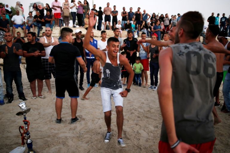 People enjoy themselves along the shore of the Mediterranean Sea during the Muslim holiday of Eid al-Adha at a beach in Tel Aviv