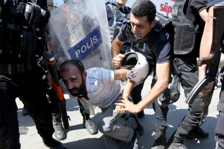 Riot police detain a demonstrator during a protest against suspension of teachers from classrooms over alleged links with the Kurdish militants, in the southeastern city of Diyarbakir