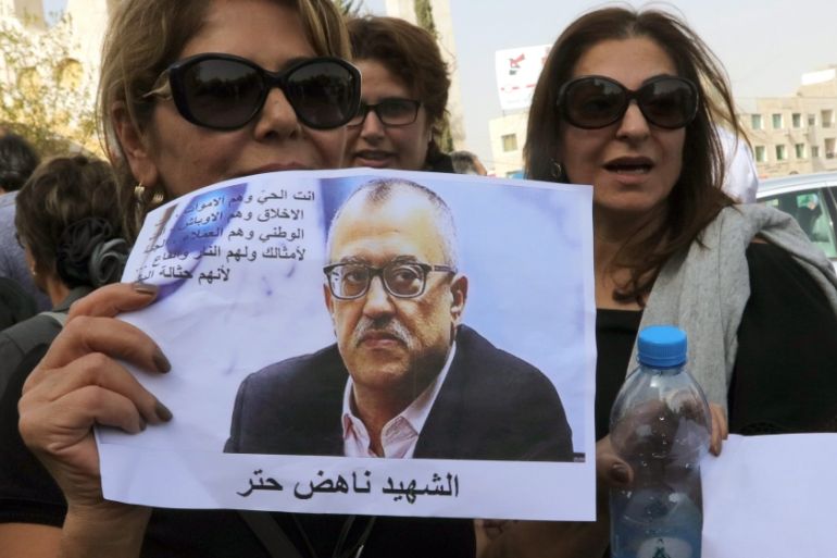Women hold photo of Jordanian writer Nahed Hattar, who was shot dead earlier in the day, in Fuhais, Jordan [EPA]