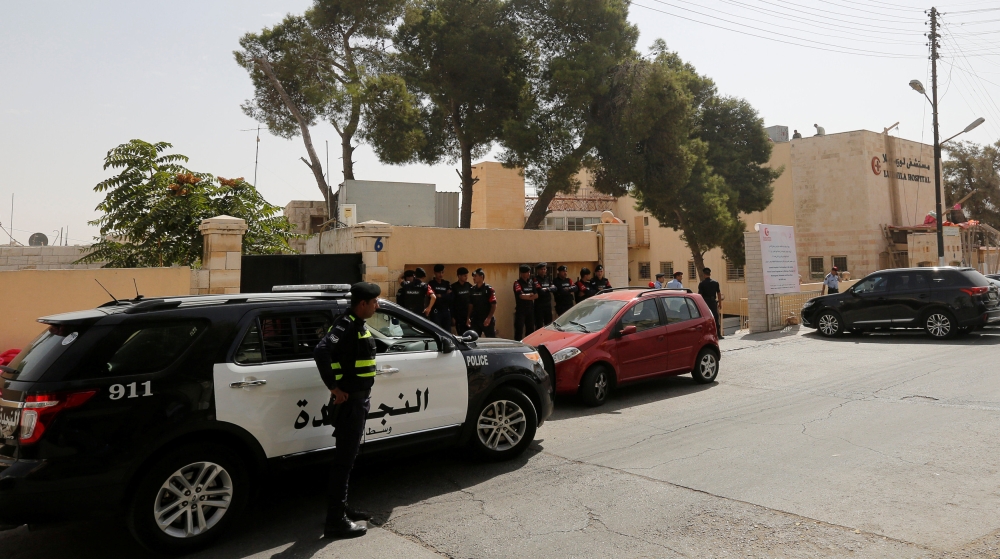 Police stood guard in front of a hospital where Hattar's body was held in Amman [Muhammad Hamed/Reuters]