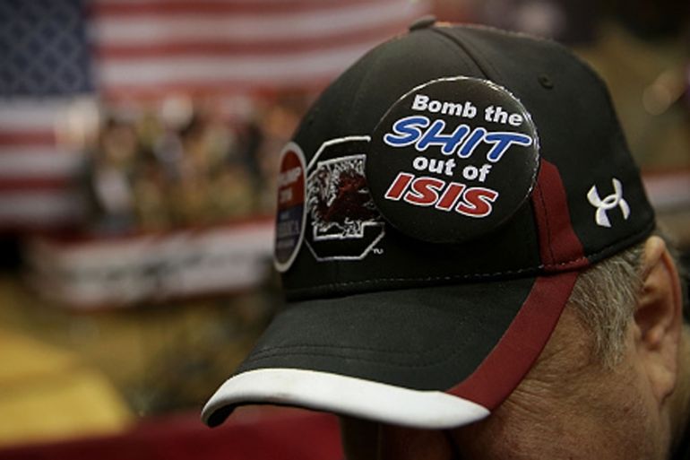 A Trump-supporter pins an anti-ISIL button on his hat during a campaign rally in South Carolina [Getty]