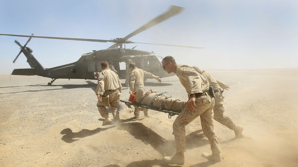 US Marines carry an injured fellow Marine to an Army Medevac helicopter in September 2010 near Marja, Afghanistan [Scott Olson/Getty Images]