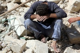 A man reacts on the rubble of damaged buildings after losing relatives to an airstrike in the besieged rebel-held al-Qaterji neighbourhood of Aleppo