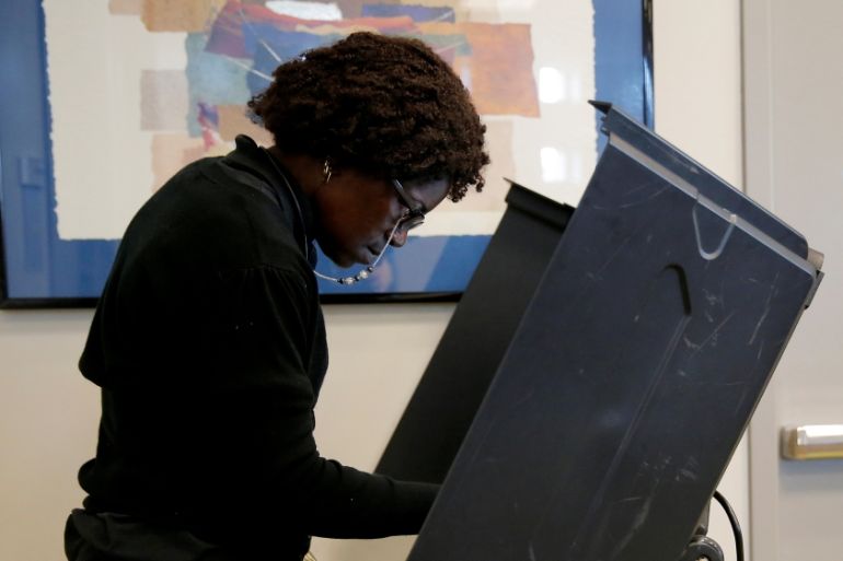 A voter casts her ballot during early voting at the Beatties Ford Library in Charlotte, North Carolina