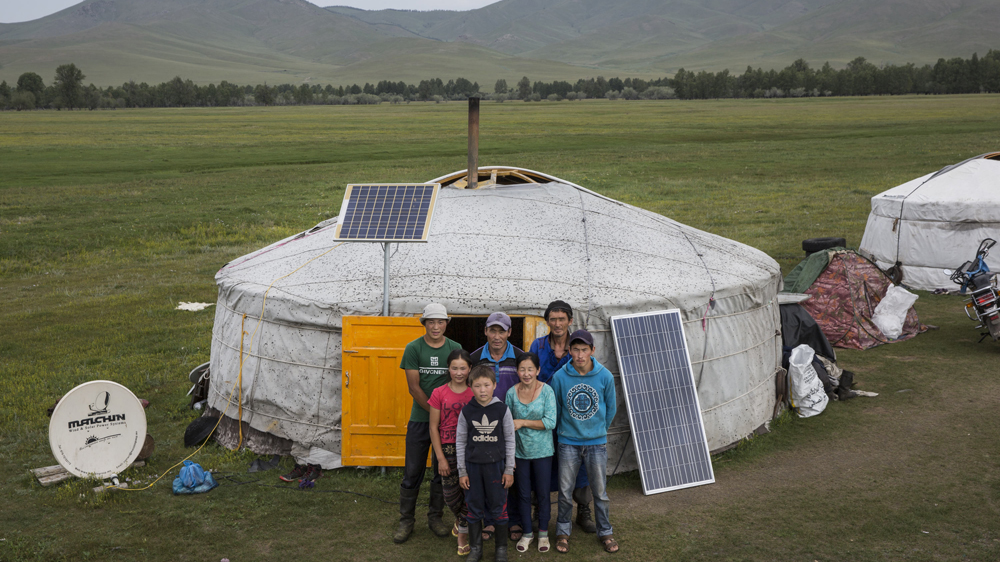 A herding family poses for a portrait in front of their home in Ikh Tamir, Mongolia [Taylor Weidman/Al Jazeera]