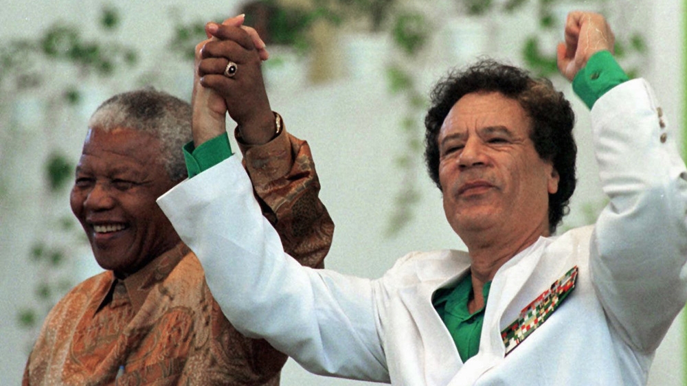 Libyan President Muammar Gaddafi, right, and South African President Nelson Mandela salute the crowd as they arrive at the congress centre in Zuwarah, Libya [AP Photo/Enric Marti] 