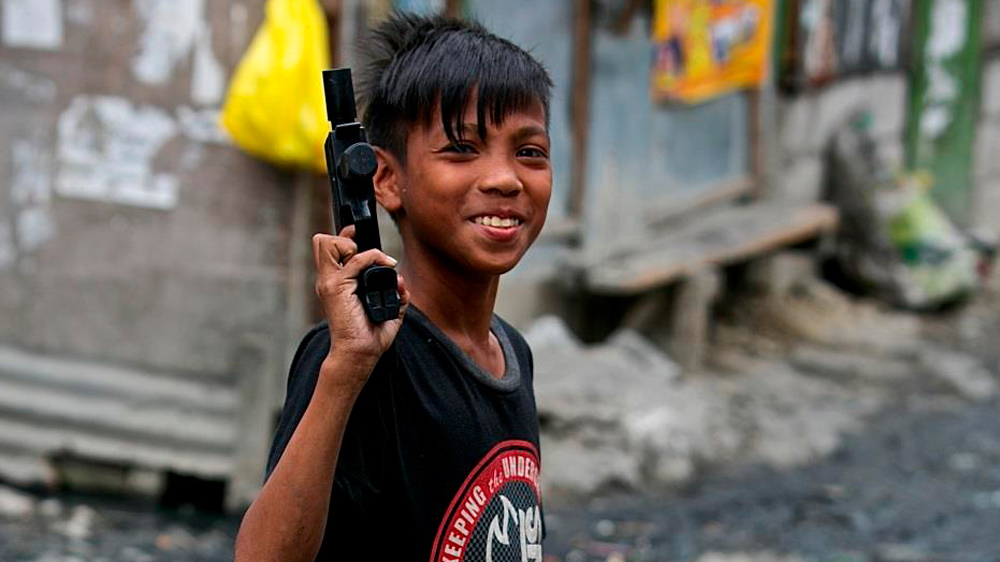 Children in many of the Philippines' poorest areas learn early that guns, rather than laws, hold power [Steve Chao /Al Jazeera]