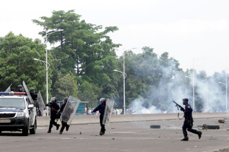 Congolese policemen run to their vehicle during a clash with opposition activists participating in a march to press President Joseph Kabila to step down in the DRC''s capital Kinshasa