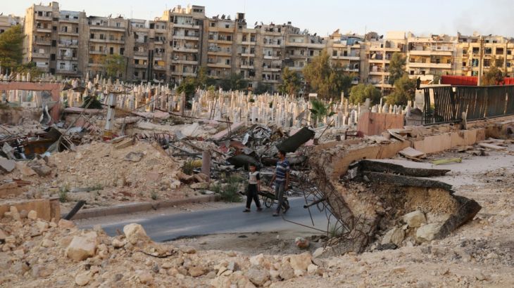 People walk near an over-crowded graveyard in the rebel held al-Shaar neighbourhood of Aleppo